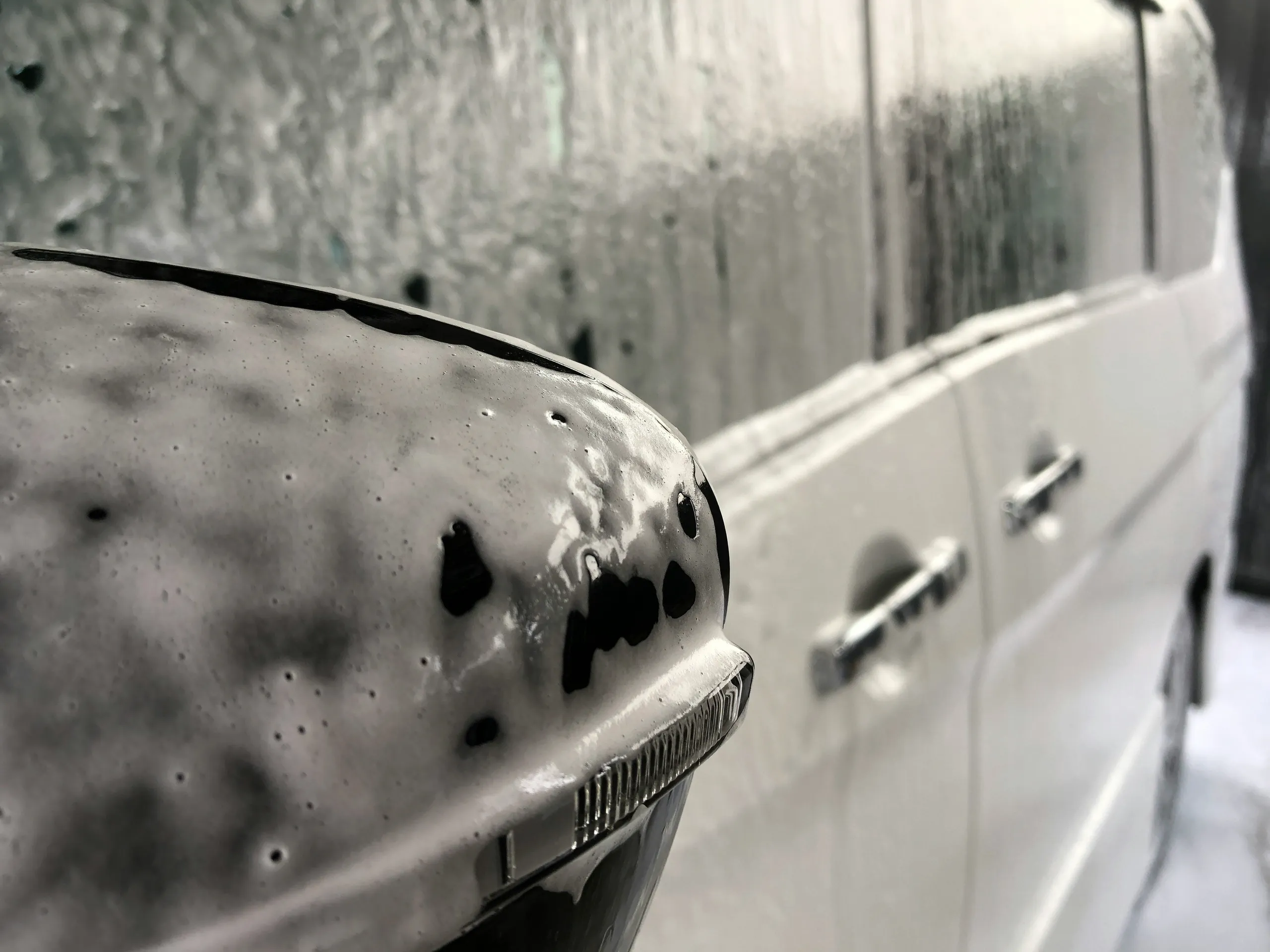 Coche en un garaje profesional de detailing con agua pulverizada